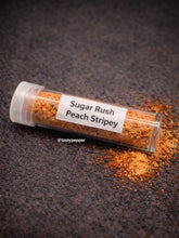 Load image into Gallery viewer, Small transparent tube labeled 'Sugar Rush Peach Stripey' filled with an orange spice on a dark surface.