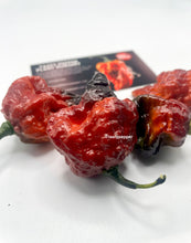 Load image into Gallery viewer, Gator Jig-saw orange chili peppers on a white surface with a branded card in the background.
