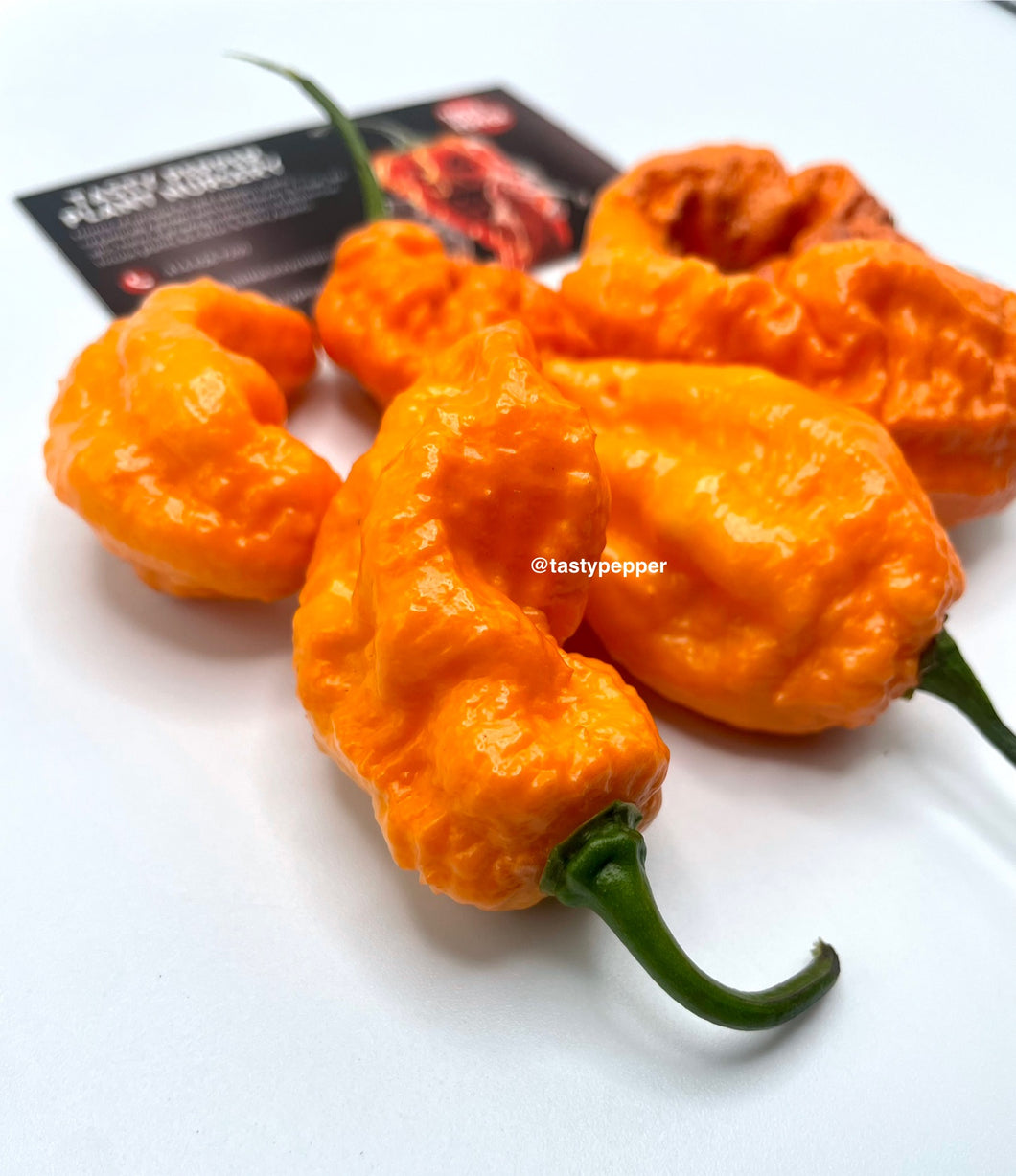 Jays peach ghost scorpion peppers on a white background with 'tasty pepper' branding.